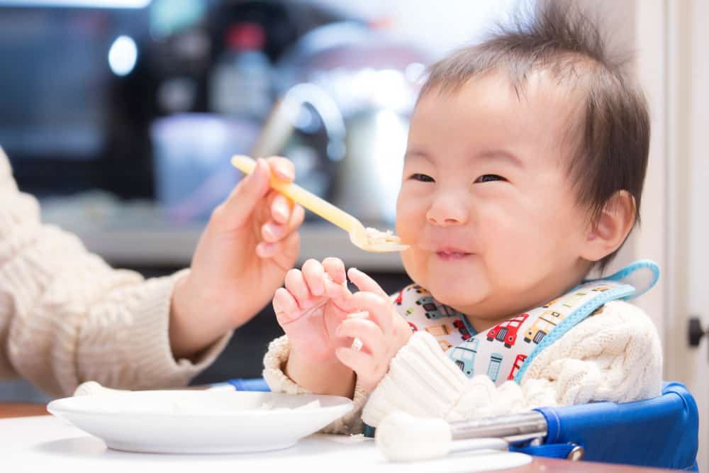 potret bayi menikmati makanan bergizi untuk anak sebagai mpasi 6 bulan pertama setelah pemberian asi eksklusif